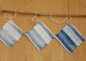 pieces of striped dyed blue cloth are hanging up