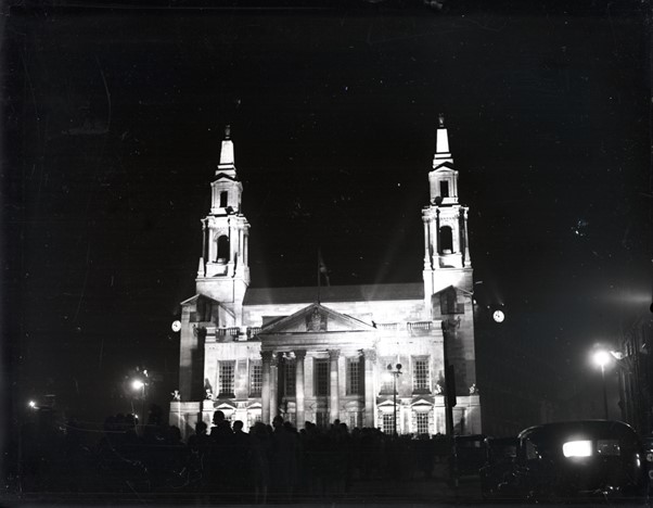 A black and white image of Leeds Civic Hall lit up