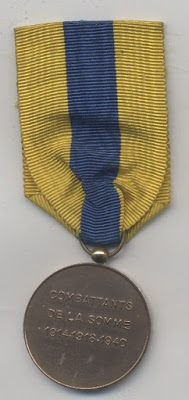 A medal with a blue and yellow striped ribbon.