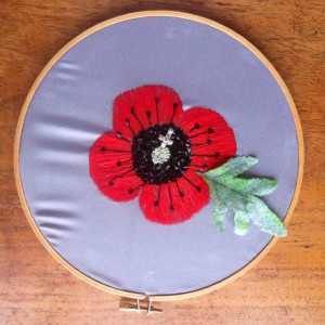An embroidered poppy by a member of Peer Support