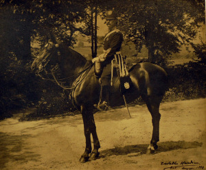 A sepia photograph of a colonel riding a horse.