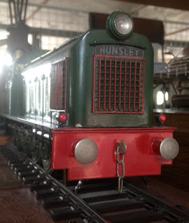 The front of a small train model with the word hunslet written on.
