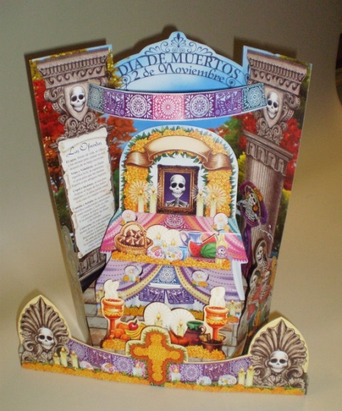 An image of a typical Day of the Dead altar - it is colourful and made of card, and adorned with skulls.