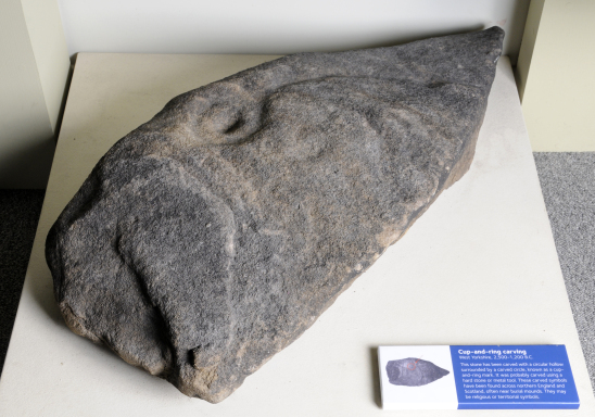 A large pointed stone, with a swirled indent in the top.