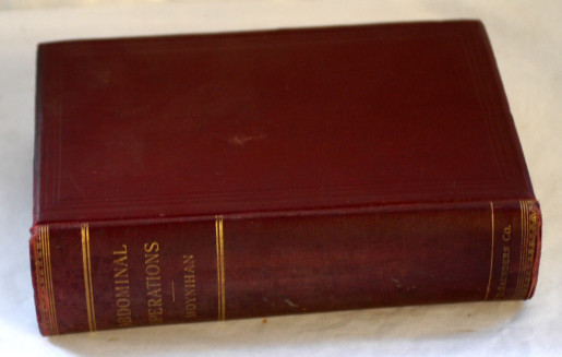 Photo of a book on a white background. The book is dark red with gold details and writing. You can read Abdominal operations, Moynihan on it's side.