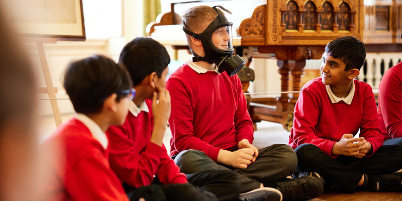 A group of schoolchildren at Lotherton, one is wearing a gask mask as part of the workshop