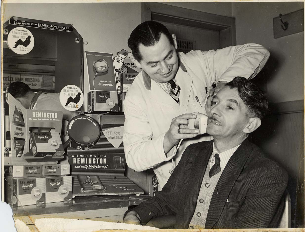 black and white photo of gentleman having a shave at a barber shop