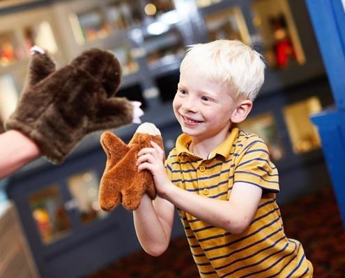 A young boy playing with a fluffy puppet toy at Abbey House Museum