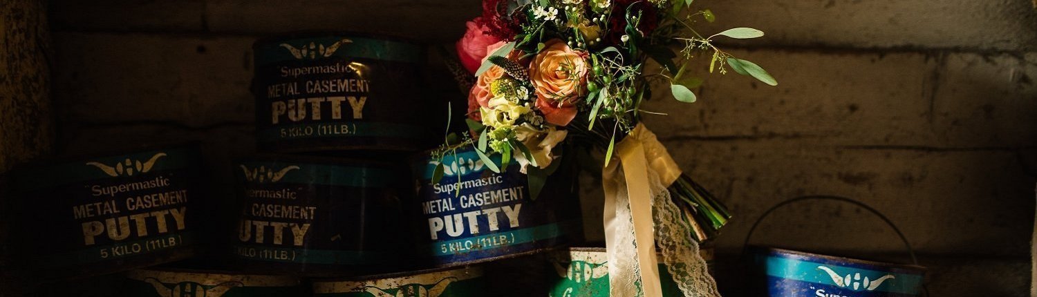 Wedding bouquet in front of several cans of metal casement putty