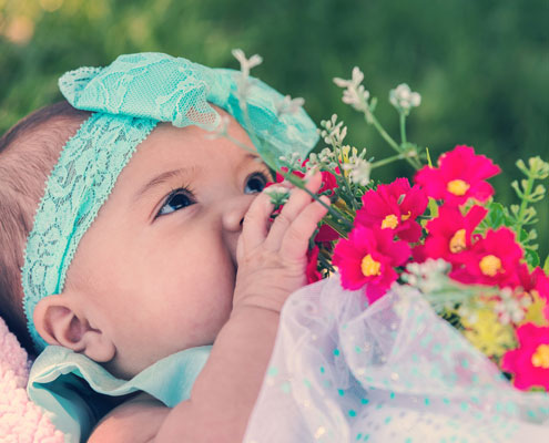 A baby with flowers to one side