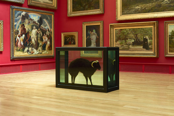 Damien Hirst art work of a sheep in a glass case on display amongst calssical paintings in an art gallery