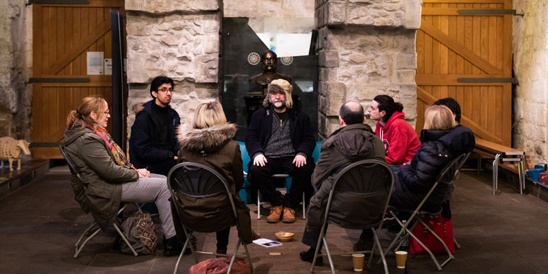A group of adults sat in the Colonel North room at Kirkstall Abbey as part of a mindfulness session