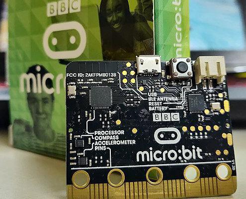 a BBC micro:bit with laptop in the background