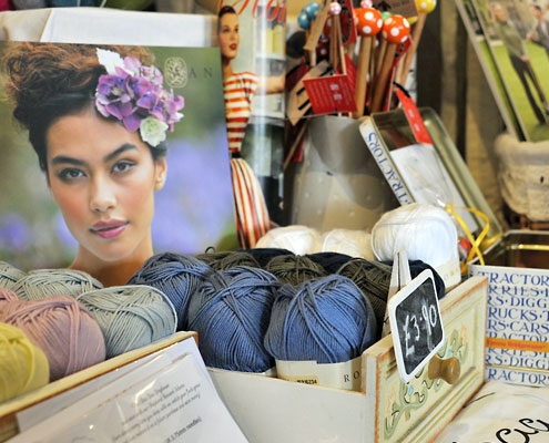 A craft stall with wool and other knitting related items on display