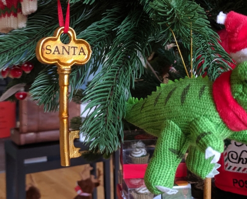 A knitted dinosaur decoration on a Christmas tree at Leeds City Museum shop