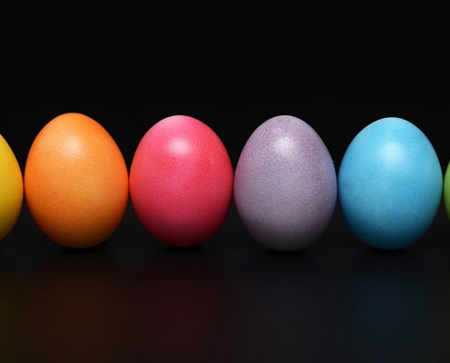 Brightly coloured painted eggs on a black background