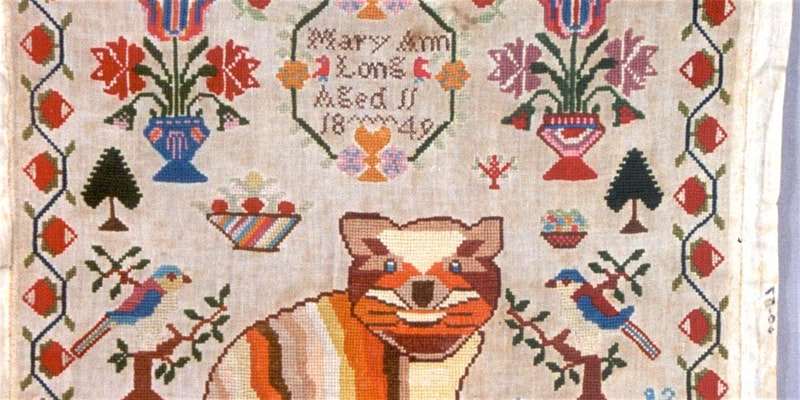 A close up of an embroidered sampler