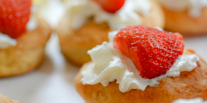 Pastry desserts with cream and a strawberry on the top