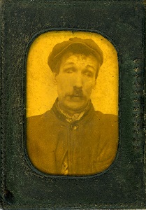 A sepia photograph of a man wearing a flat cap.