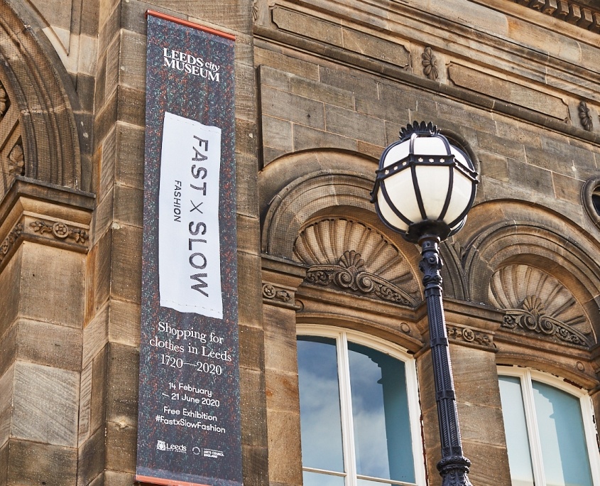 The exterior of Leeds City Museum showing the banner for Fast x Slow Fashion exhibition
