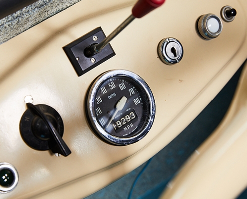 A cream coloured interior and dashboard of a 1950s blue Scootacar