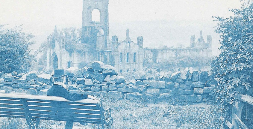 A cyanotype photograph of Washington Teasdale sat on a bench looking out over Kirkstall Abbey. This is supposedly the first selfie ever taken, captured in the 1800s
