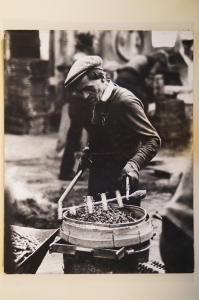 A black and white photograph of a man workng in a seg factory.