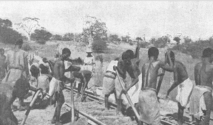 a black and white image of black workers building a railway.