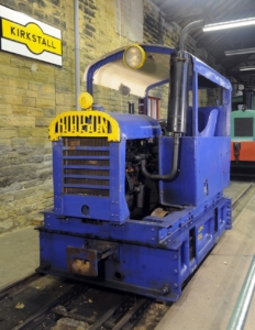 A blue train car in a museum building.