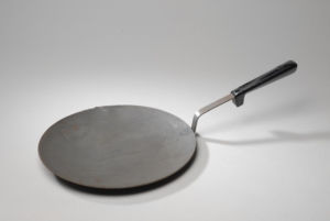 A metal cooking pan, that looks like a flat frying pan