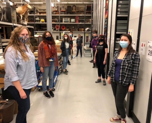 A group of young people are standing in an artefact store and wearing a mask