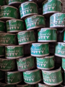 A stack of green putty tins in a museum
