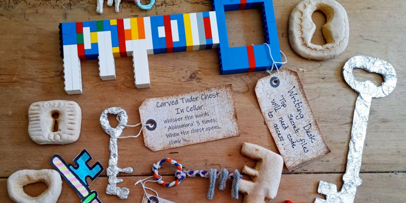 A selection of homemade keys laid out on a wooden table. Some of the keys have been shaped by pipe cleaners, Lego and clay.