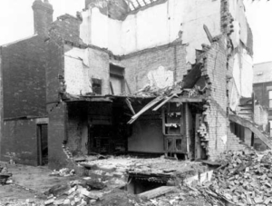 A black and white photograph of a bombed house.