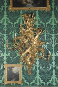 An elaborate gold candle holder on a wall