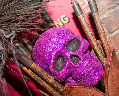 A pink skull in amongst some old fashioned brushes in the Victorian Streets of Abbey House Museum