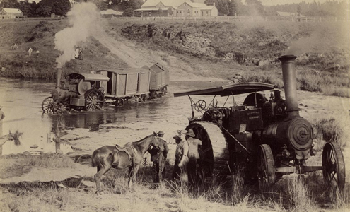 An old black and white photograph of steam trains, workers and horses