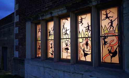 Some festive stained glass windows are up lit at night in Temple Newsam House