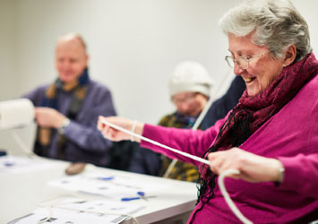 An elderly visitor engaging with craft activities at Leeds Art Gallery