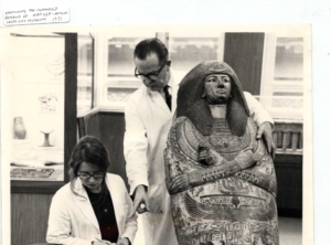 2 Scientists are holding the sarcophogus of an Egyptian mummy