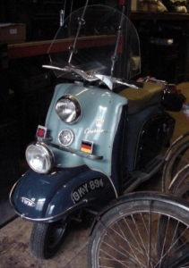 A triumph werke scooter in a museum, seen from the front