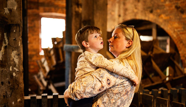 A woman holds her son inside Thwaite Watermill