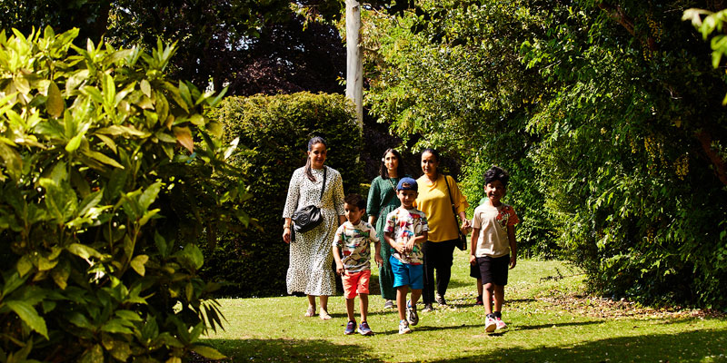 A family including three women and three young boys walking through the gardens of Lotherton in summer
