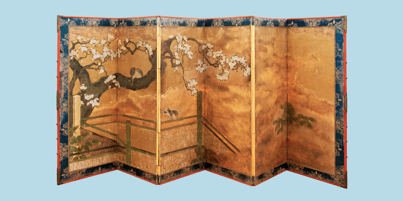 A gold decorative screen with Japanese cherry blossom painted. On display at Lotherton.