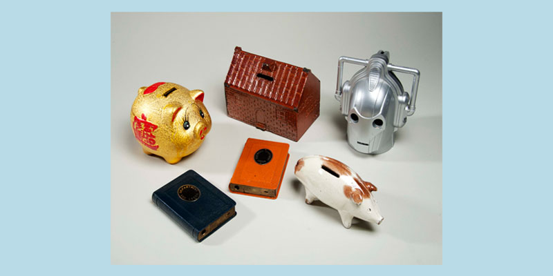 A selection of different money boxes including a lucky pig, a robot and a house.