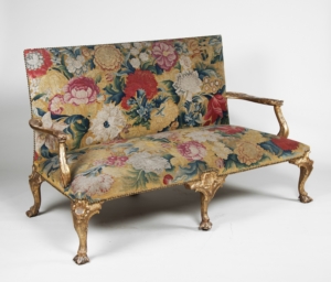 Floral sofa with gold legs.