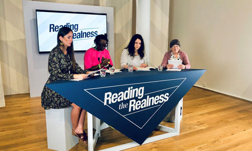 Four participants are reading scripts on the set of Reading the Realness at Leeds Art Gallery