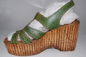 A green slingback sandal with a crack in the platform sole.