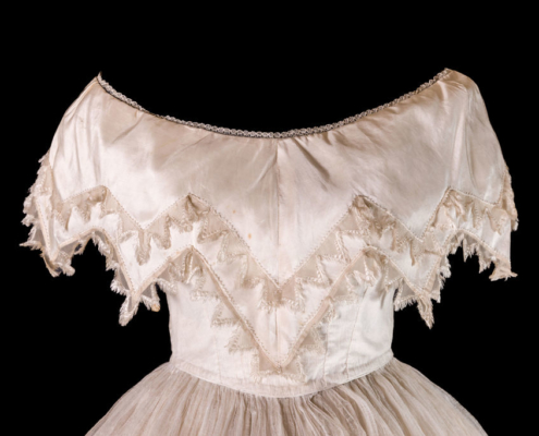 Detail of the sleeve and top half of a white ball gown