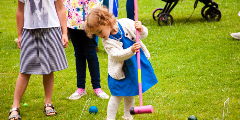 Young girl using a croquet stick